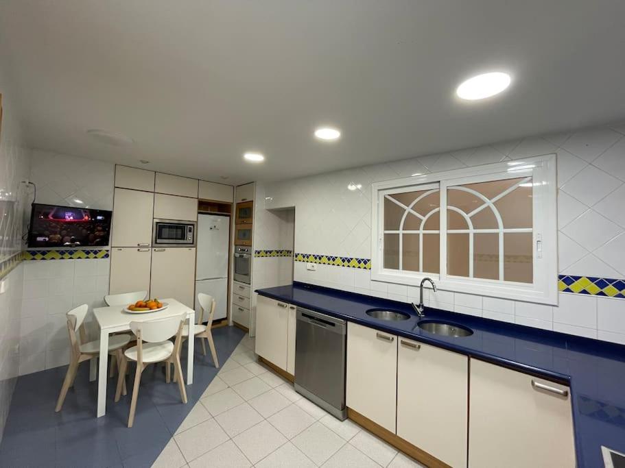 eine Küche mit Spüle und Tisch mit Stühlen in der Unterkunft Apartamento en el centro urbano in Vilanova i la Geltrú