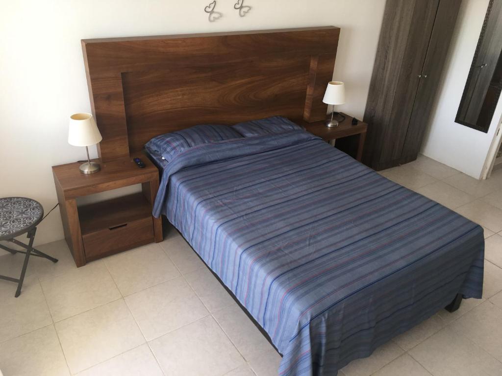 a bed in a bedroom with two night stands and two lamps at Departamento con vista al mar in Acapulco