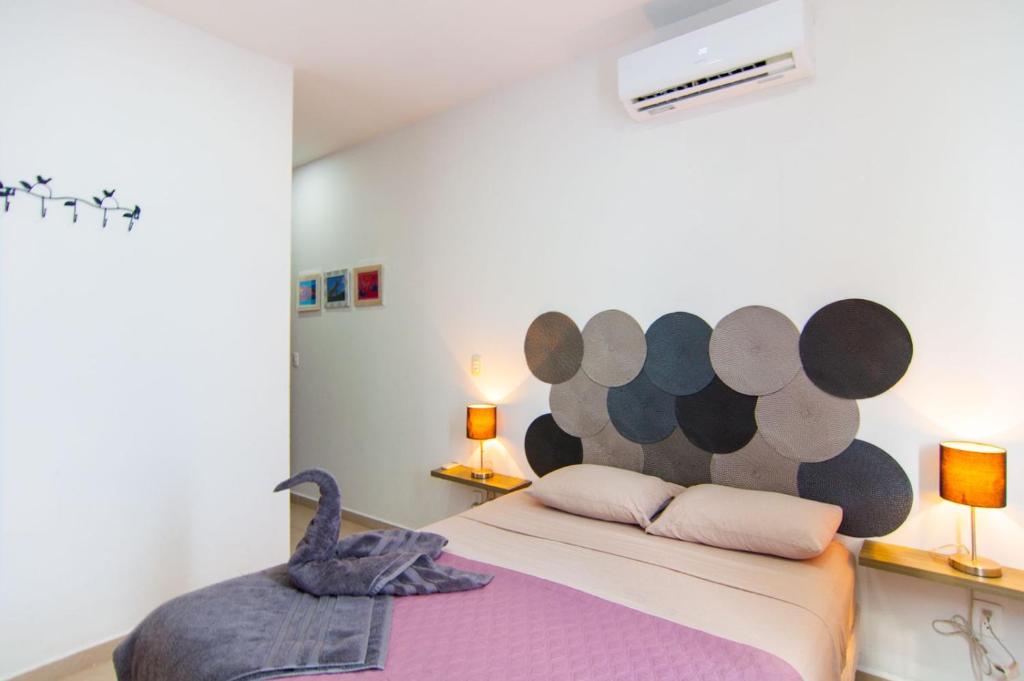 a bedroom with a bed with a swan on it at Paraíso Casa Turquesa Playa del Carmen in Playa del Carmen