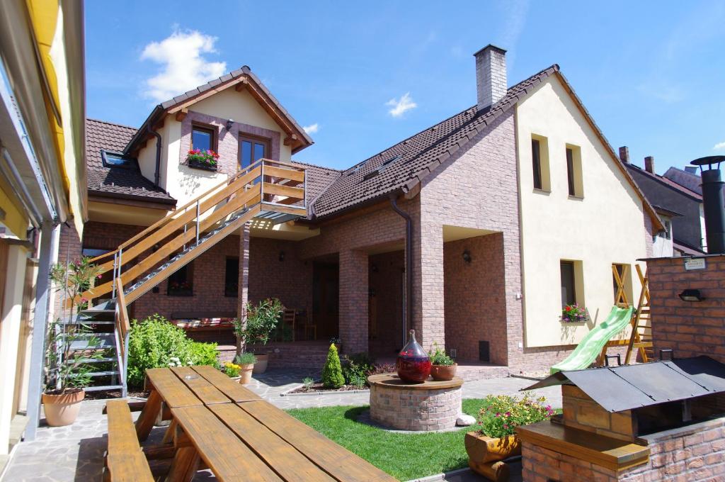 een achtertuin met een houten bank en een huis bij Ubytování a apartmány Sluníčko in Lomnice nad Lužnicí