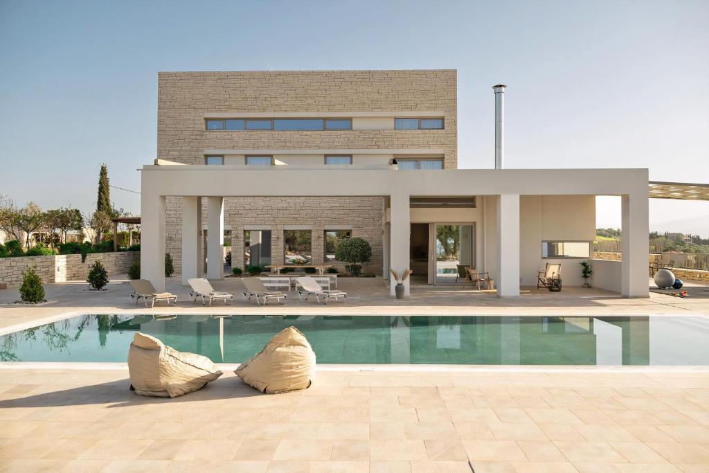 a house with a swimming pool in front of it at Diktamon Retreat Luxus Villa in Heraklion