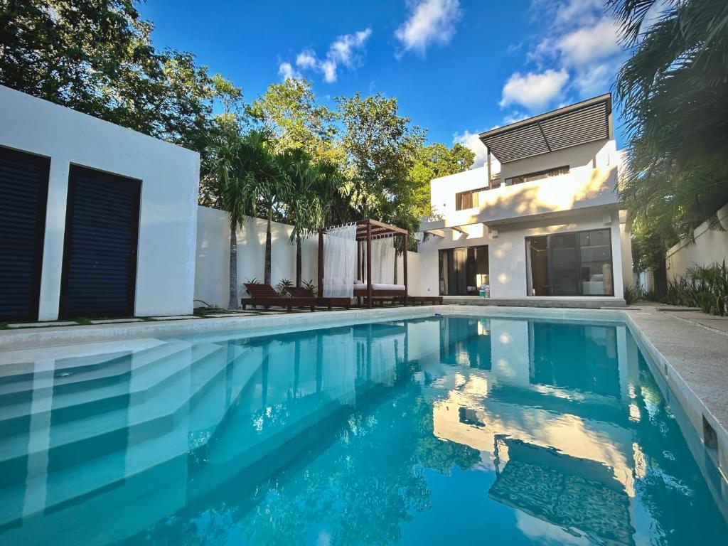 a swimming pool in front of a house at Stunning Villa in the heart of La Veleta in Tulum