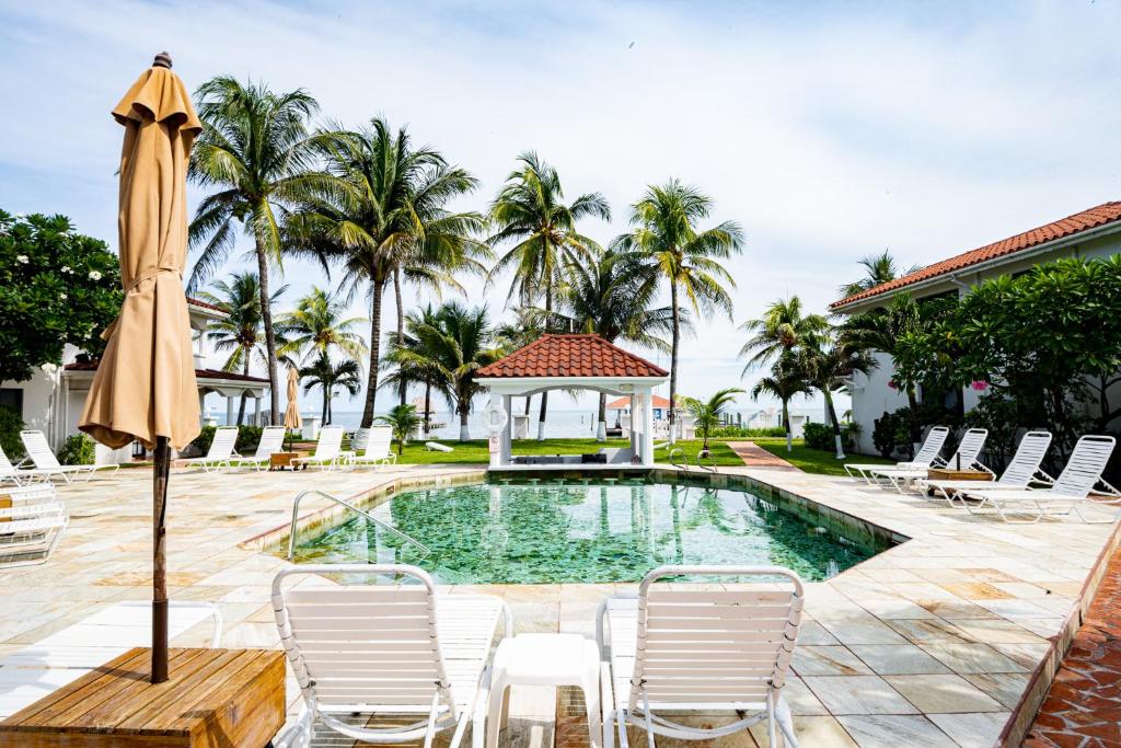a pool with chairs and an umbrella and a gazebo at Isla Bonita Yacht Club in San Pedro