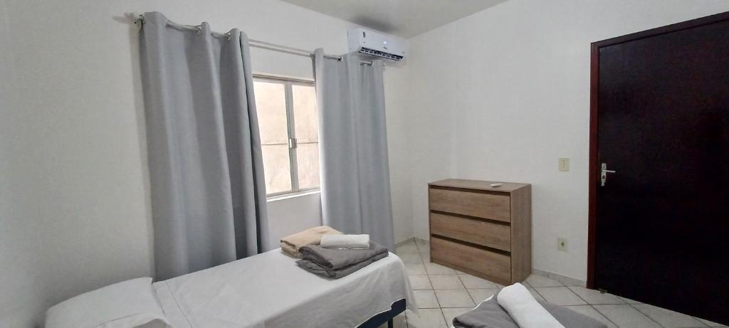 a bedroom with a bed and a dresser and a window at Apto 102 Figueira Parque - Mobiliado 2 quartos in Jaraguá do Sul