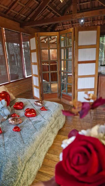 a room with a bed with red roses on it at Cabana Spa São Roque in São Roque