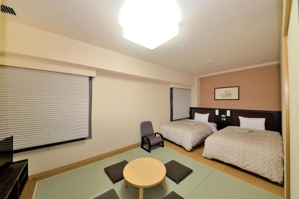 Postel nebo postele na pokoji v ubytování Toyama Manten Hotel