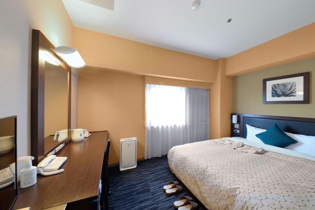 Postel nebo postele na pokoji v ubytování Toyama Manten Hotel