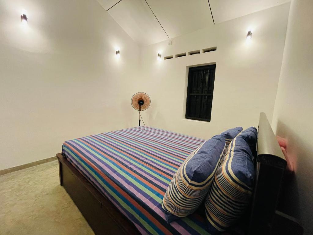 ein Schlafzimmer mit einem Bett mit blauen Laken und einem Fenster in der Unterkunft Berg house mirissa in Mirissa