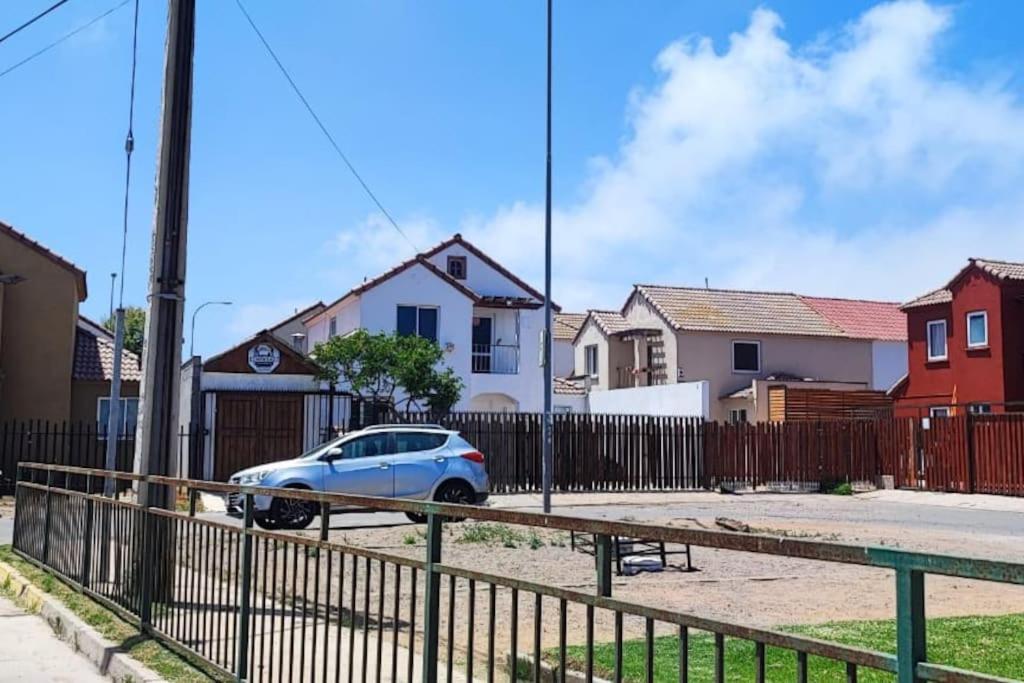a blue car parked in front of a fence at Casa acogedora puertas del Mar in La Serena