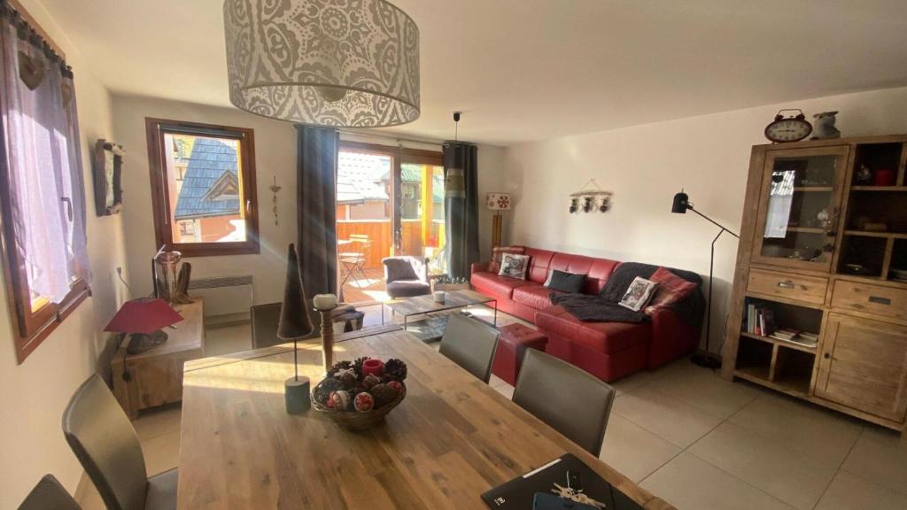 un salon avec un canapé rouge et une table dans l'établissement Résidence Grange Catharina - Superbe appartement a proximité des pistes et des commerces MAE-7704, à Montgenèvre