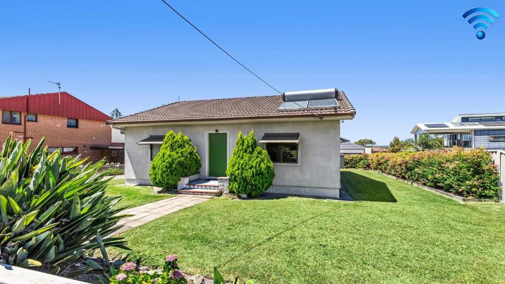 a small house with a green door in a yard at Time To Unwind in Culburra Beach