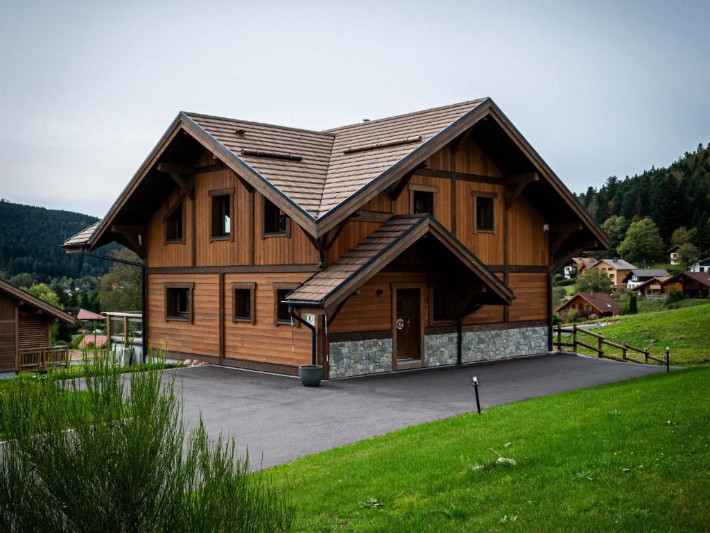 a large wooden house with a gambrel roof at Chalet familial avec sauna et terrasse près du lac - FR-1-589-758 in Xonrupt-Longemer