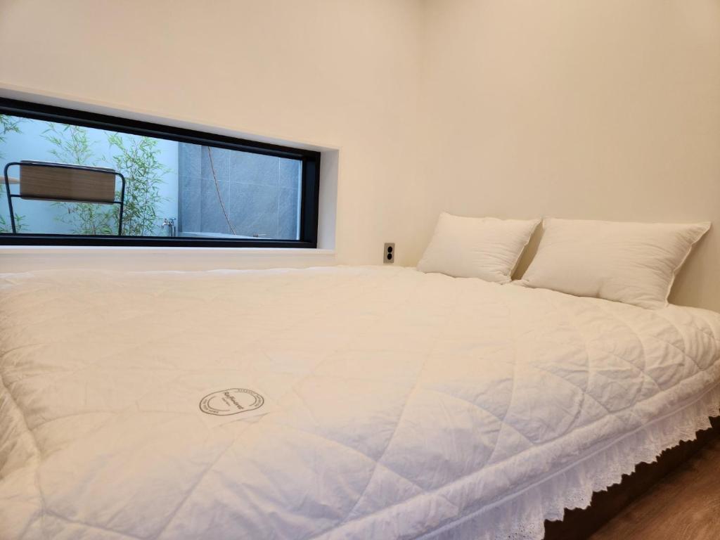 un grande letto bianco in una stanza con una finestra di Damonga a Damyang