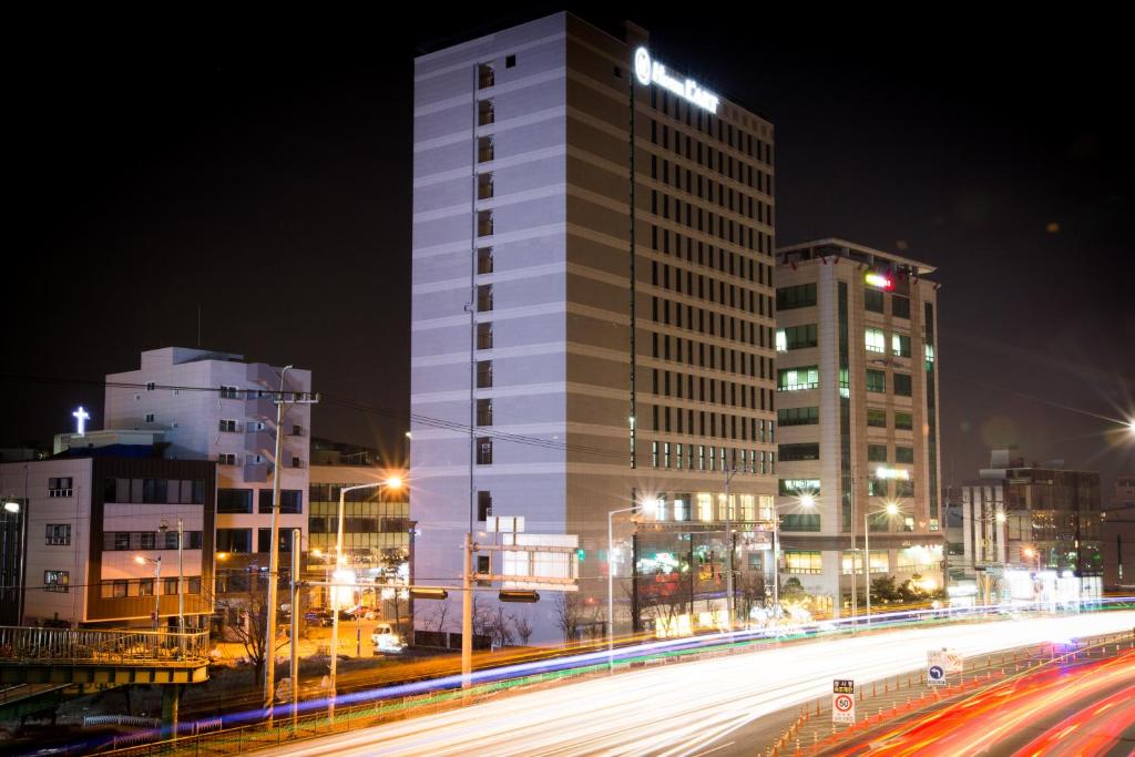 un grand bâtiment blanc dans une ville la nuit dans l'établissement Hotel L'art Gimpo, à Gimpo