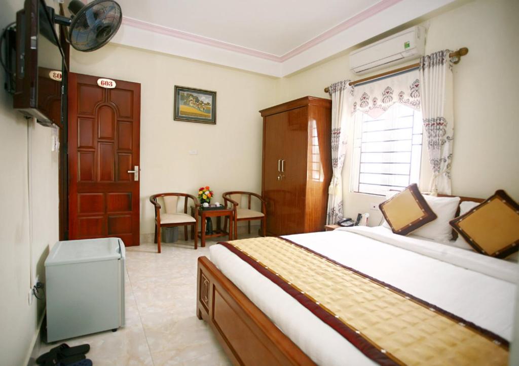 a bedroom with a bed and a window and a door at Bao An Hotel in Diện Biên Phủ