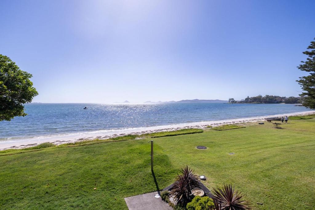 a golf course with a view of the ocean at Boondelbah 4, 29 Soldiers Point Rd - waterfront bliss in Soldiers Point