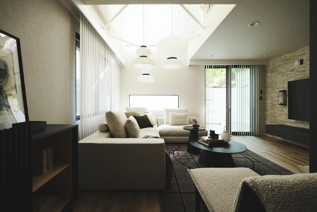 ein Wohnzimmer mit Sofa und Tisch in der Unterkunft New open 都心の一軒家貸切 232平米 新宿駅4分 渋谷10分 無料駐車場3台 最寄駅2分 in Tokio