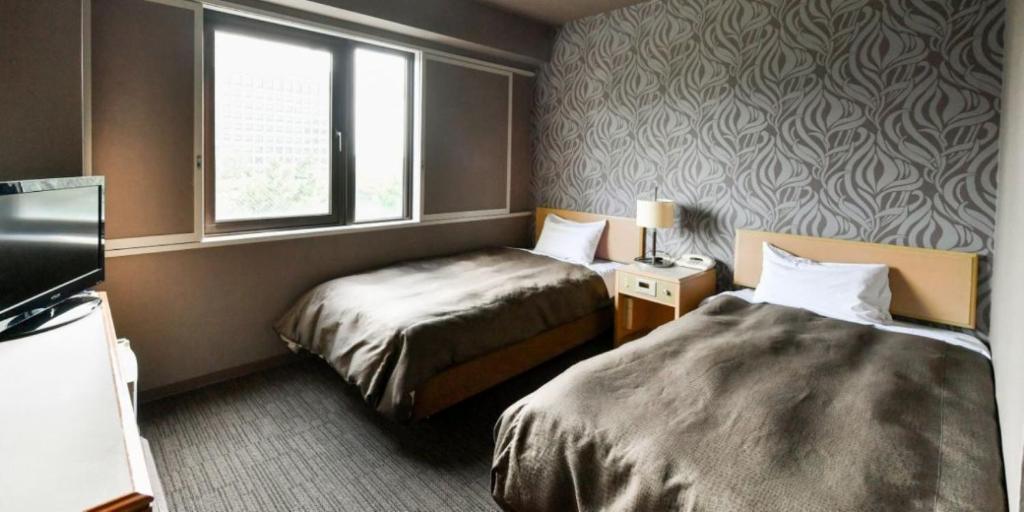 Postel nebo postele na pokoji v ubytování Okazaki Daiichi Hotel