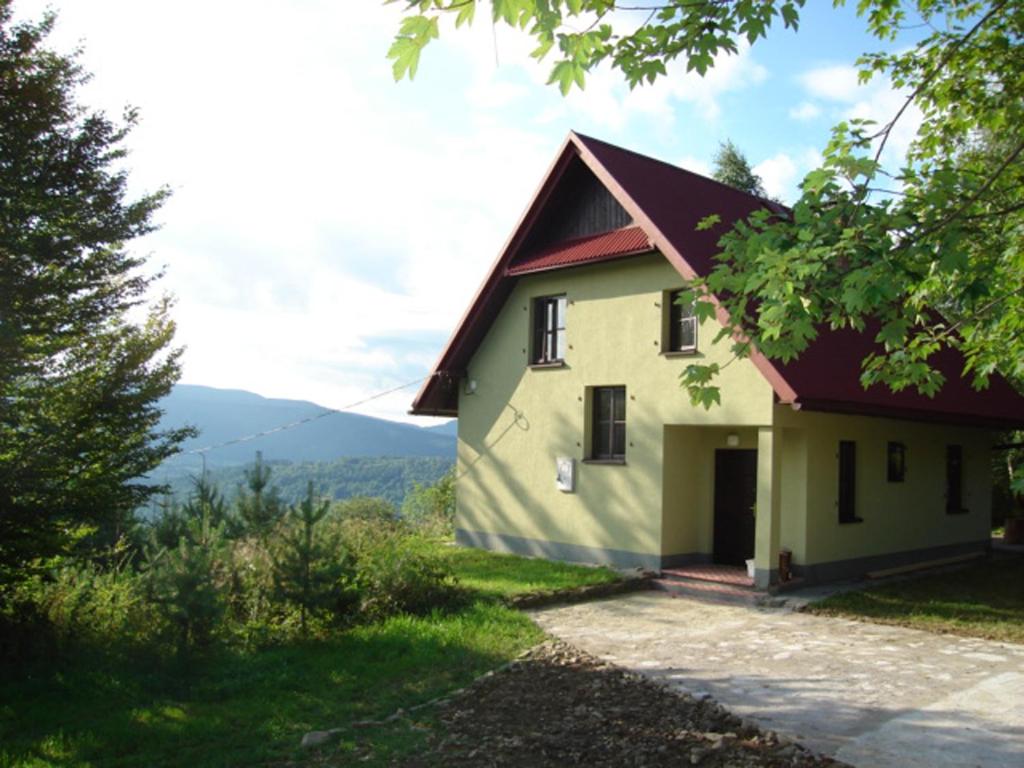 una casa con techo rojo en una colina en Kolędówka Rest, en Zawoja