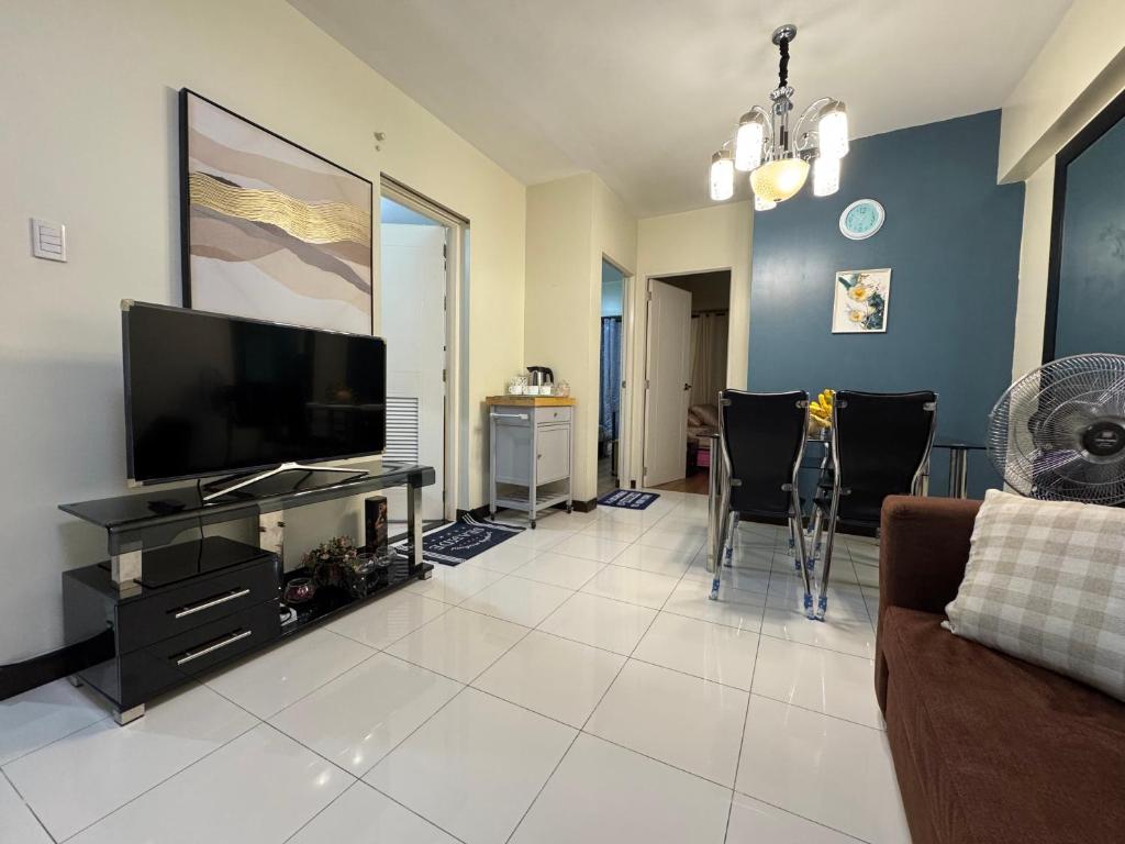 a living room with a flat screen tv and a couch at Zinnia North Tower 3202 in Manila