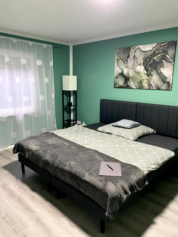 a large bed in a bedroom with a sign on it at Appartement 3 - geräumige Wohnung mit eigener Küche, Bad und Gartenblick in Salzgitter