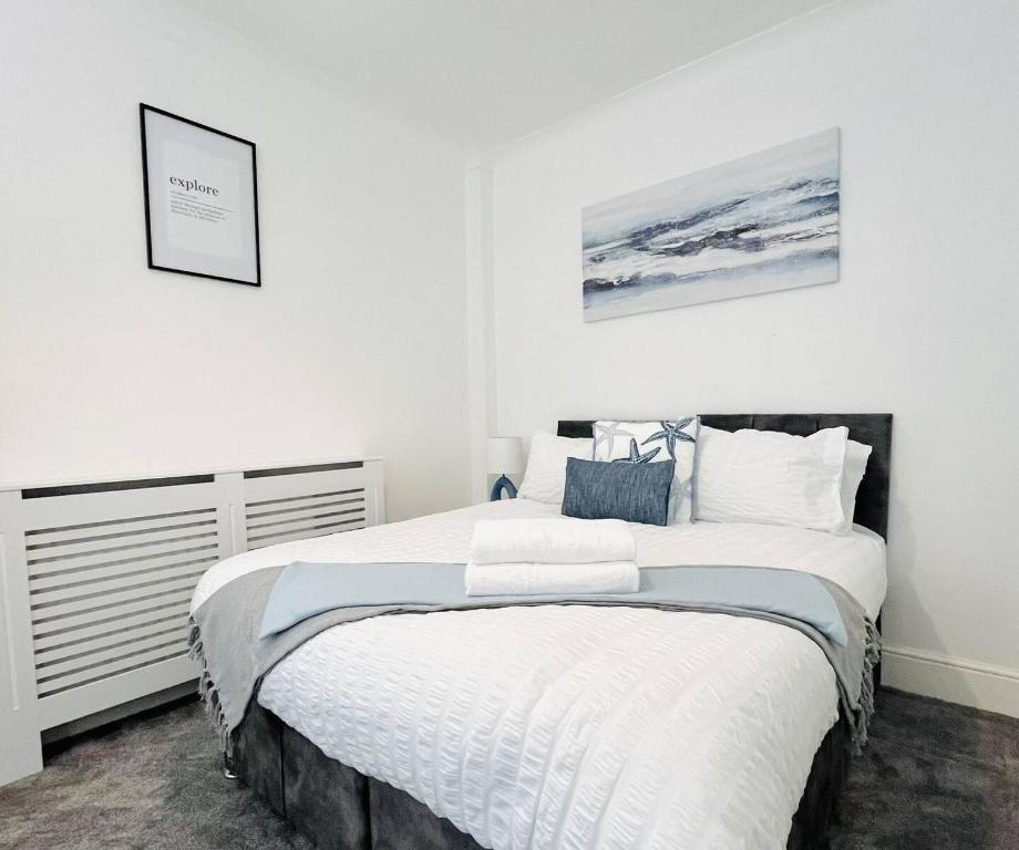 a bedroom with a large bed with white walls at Orchard Road in Portsmouth