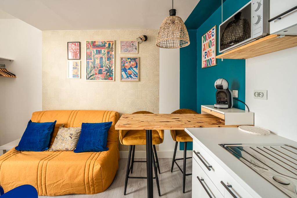 une petite cuisine avec une table et des chaises en bois dans l'établissement Studio Soleil d'Azur, à Narbonne