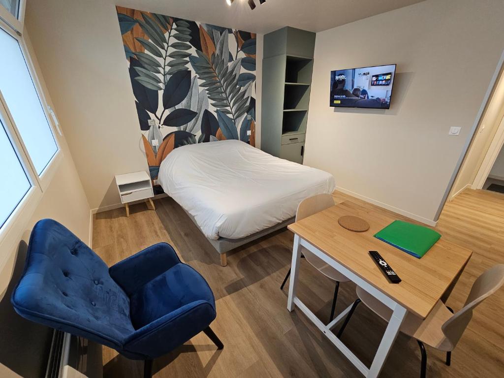 a small room with a bed and a desk and a chair at Les Gîtes du Moulin des Loups in Saint-Amand-les-Eaux