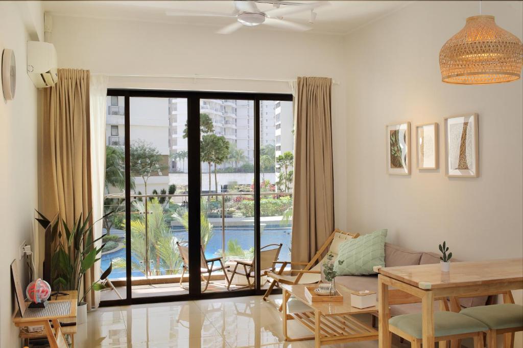 d'un salon avec une table et une grande porte coulissante en verre. dans l'établissement Kid-Loving Poolside Haven - 2BR - Netflix - Games, à Johor Bahru