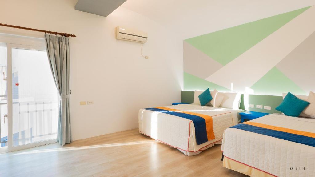 a bedroom with two beds and a window at Ocean Star B&B in Kenting