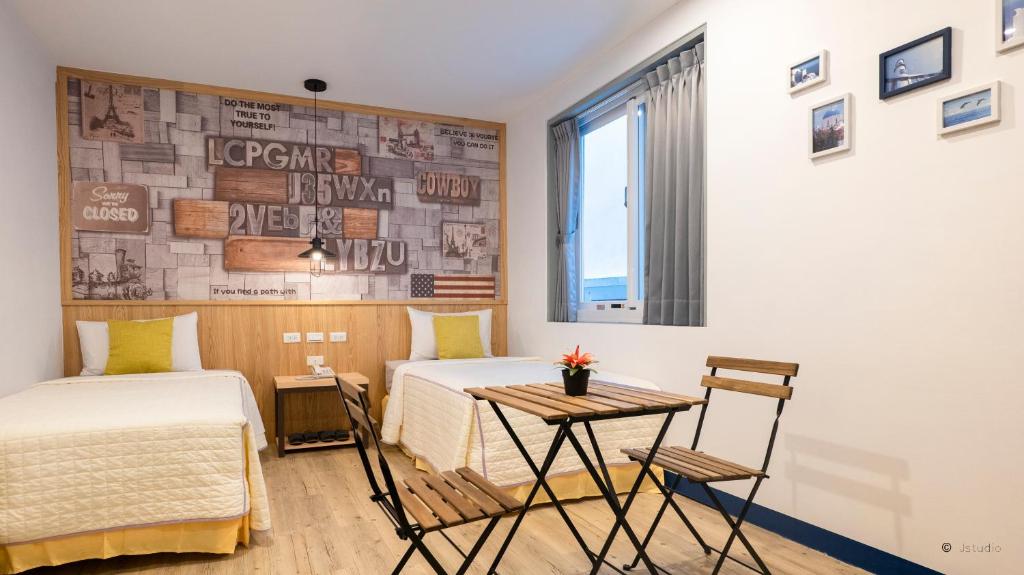 a bedroom with two beds and a table and a window at Ocean Star B&B in Kenting