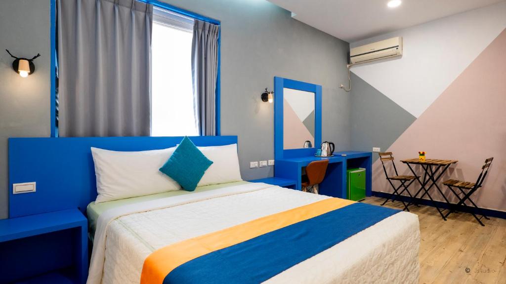 a blue and white bedroom with a bed and a table at Ocean Star B&B in Kenting