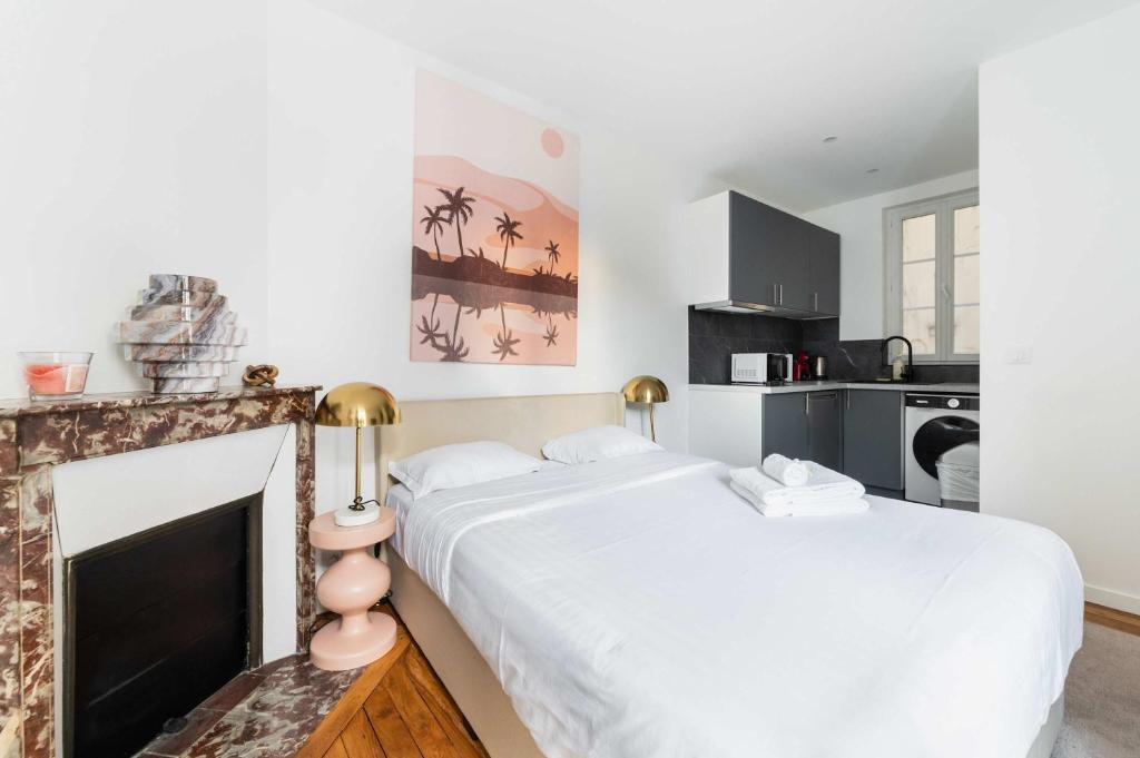 - une chambre avec un grand lit blanc et une cheminée dans l'établissement Studio neuf Metro Jaures- Paris 19 - 2P - FLAT-GUEST, à Paris