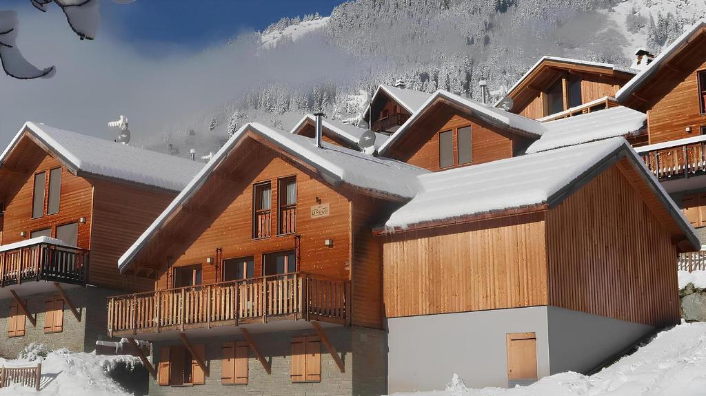domek narciarski z śniegiem na dachu w obiekcie Chalet Le Refuge w mieście Vaujany