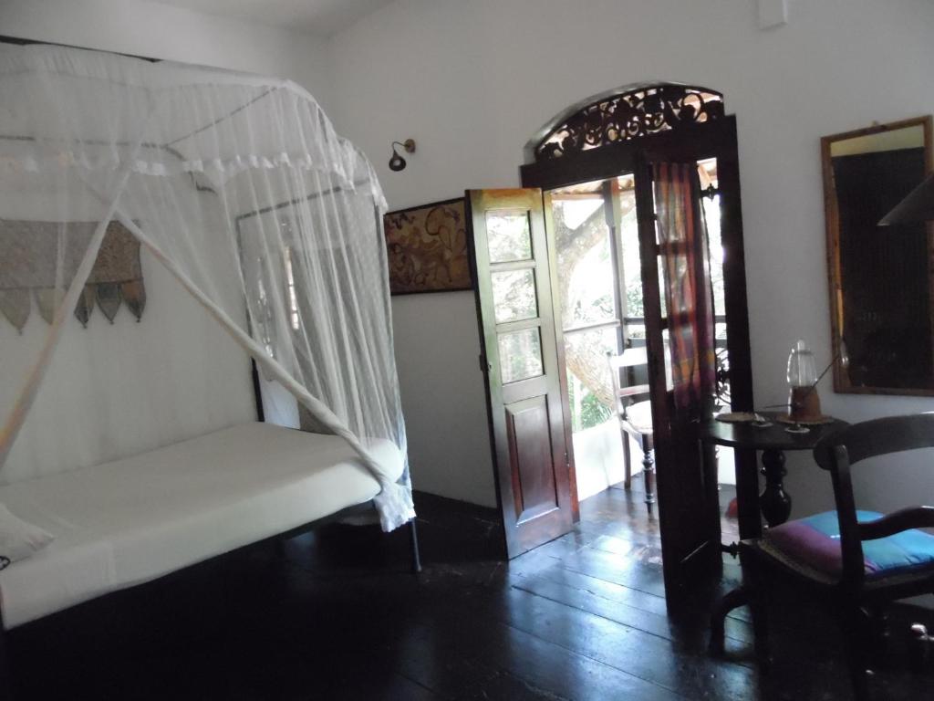 a room with a bed and an open door at The Dream House in Unawatuna
