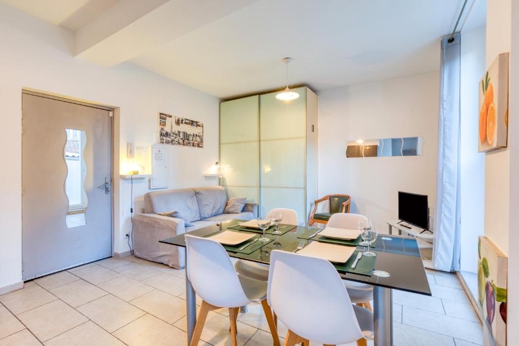 une salle à manger avec une table, des chaises et un canapé dans l'établissement Appartement La Lumineuse, à Béziers