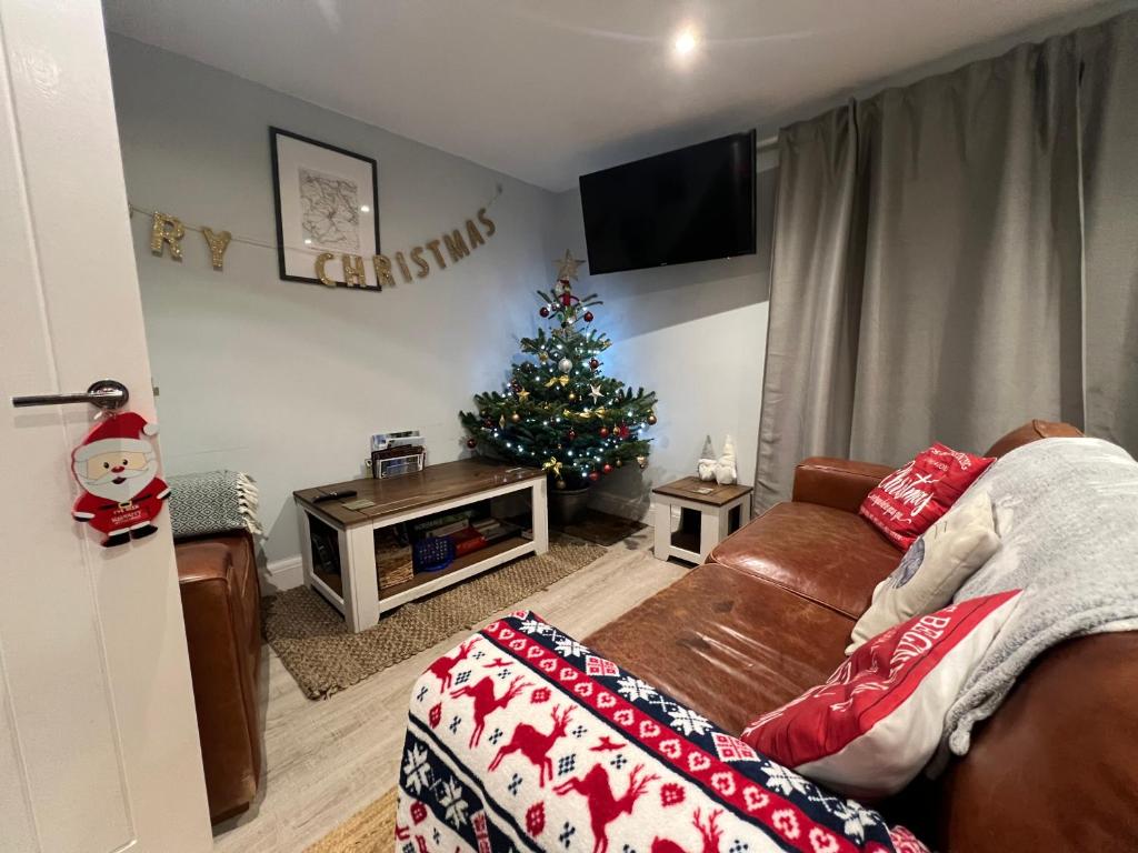 a living room with a christmas tree and a couch at Orchard Lodge -Coastal Retreat, new build, village views, private garden and terrace in Saint Brides Major
