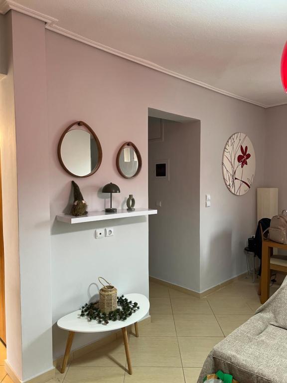 Una sala de estar con una mesa y espejos en la pared. en 19 Αri, en Tríkala