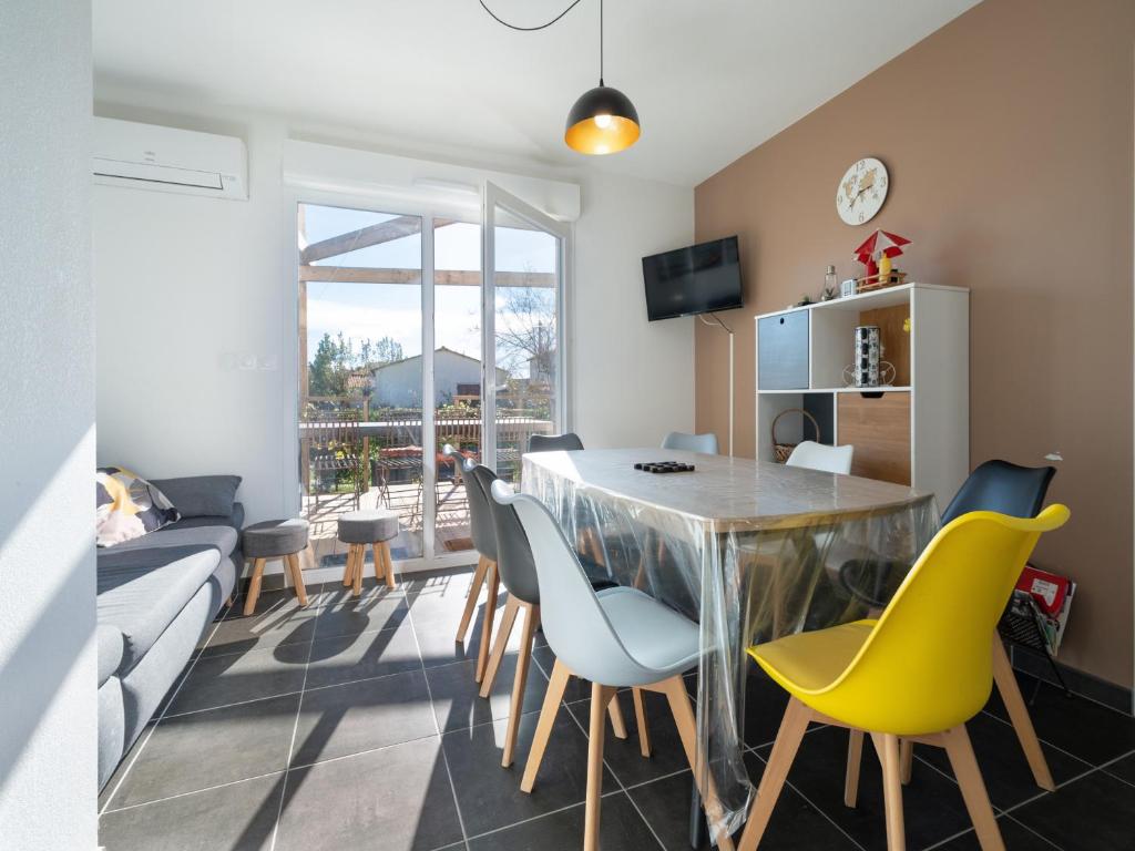 - un salon avec une table à manger et des chaises jaunes dans l'établissement La Dune N 30 - Villa 4P8, à Sérignan
