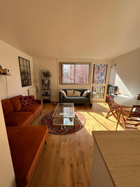 un salon avec un canapé et une table dans l'établissement Appartement lumineux Mairie des Lilas, aux Lilas