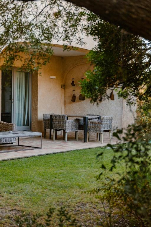 grupa ławek siedzących na ganku domu w obiekcie Cascioni Eco Retreat w mieście Arzachena