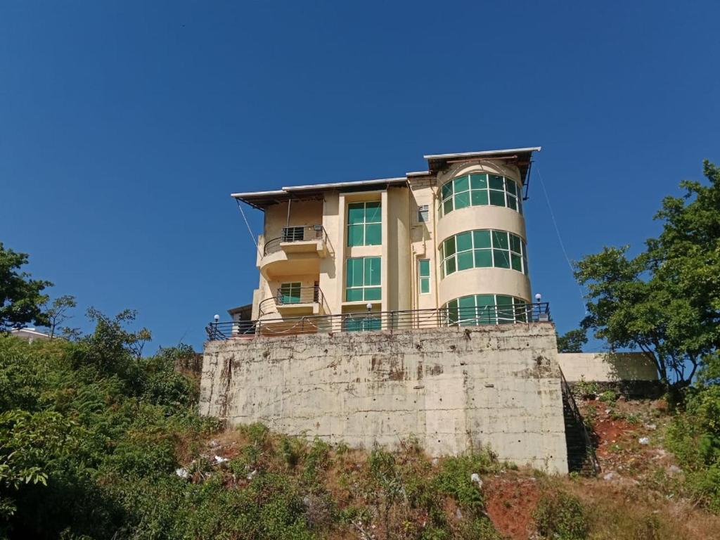 a building on top of a tower on a hill at Dev anand Villa in Mahabaleshwar
