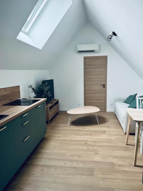 - une cuisine avec des armoires vertes et une table dans une pièce dans l'établissement Le Carcos, à Rocroi