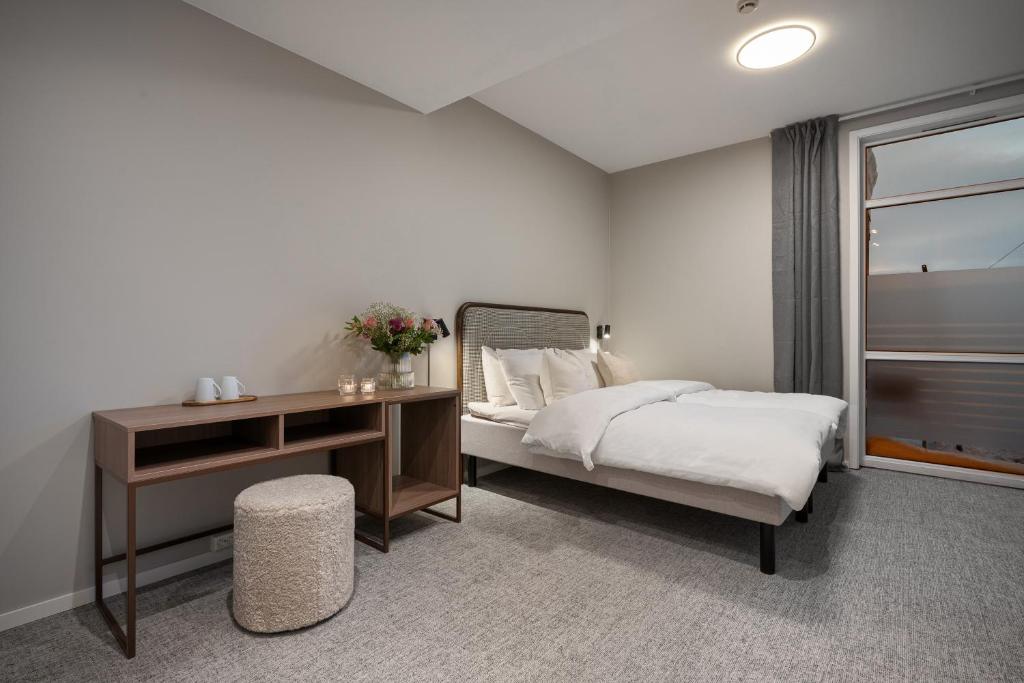 トロムソにあるEnter Skansen Hotelのベッドと机と窓のある寝室