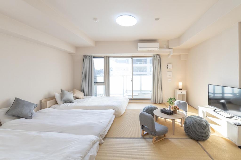 大阪市にあるRewit buildingのベッド2台とテーブルがあるホテルの部屋