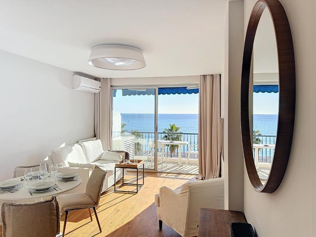 ニースにあるSeaview Promenade des Anglais 2brs apartment Parking cars 1800 kg maxのリビングルーム(テーブル付)、海を望む部屋