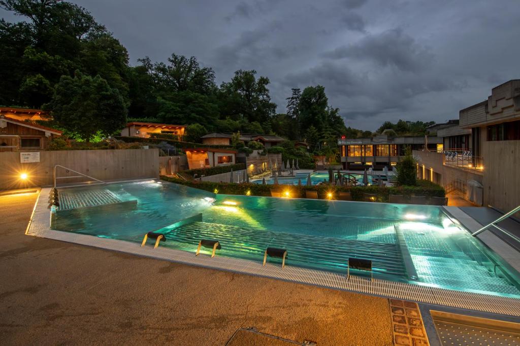 a large swimming pool at night with lights at Mondorf Parc Hotel & Spa in Mondorf-les-Bains