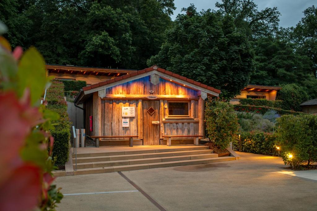 a small wooden cabin with a porch and stairs at Mondorf Parc Hotel & Spa in Mondorf-les-Bains