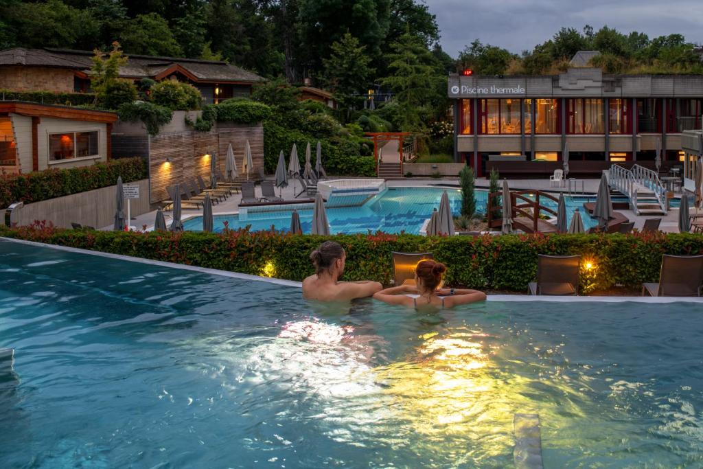 two people in a swimming pool at a hotel at Mondorf Parc Hotel & Spa in Mondorf-les-Bains
