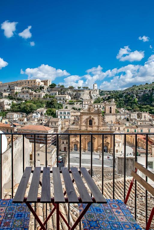 a wooden bench sitting on top of a city at Casa Teresa con vista in Modica